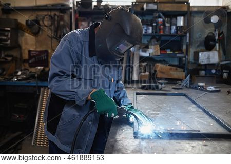 Side View Portrait Of Female Welder Working With Metal In Industrial Workshop, Copy Space