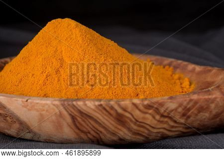 Turmeric Powder In Wooden Spoon Studio Shoot