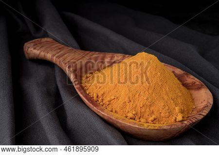 Turmeric Powder In Wooden Spoon Studio Shoot