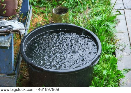 A Blue Barrel For Collecting Rainwater. Collecting Rainwater In A Plastic Container. Collecting Rain
