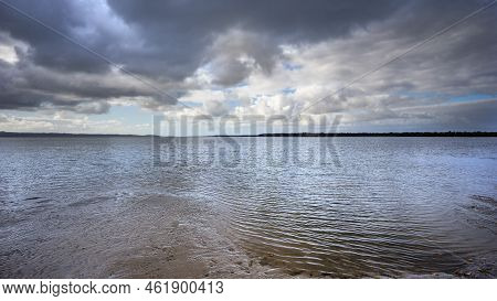 Dramatic Storm Clouds Brewing Over The Sea And Beach At Poona Beach, Queensland. Panorama Looking Ac