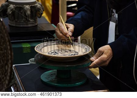 Thai Craftsmanship Technician Or Professional Ceramicist Drawing  And Painting Color On Handmade Cer