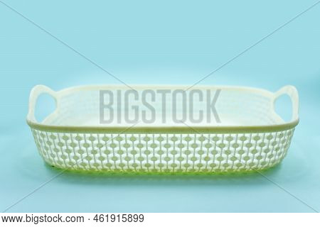 White Plastic Basket With Woven Pattern Isolated On A Turquoise