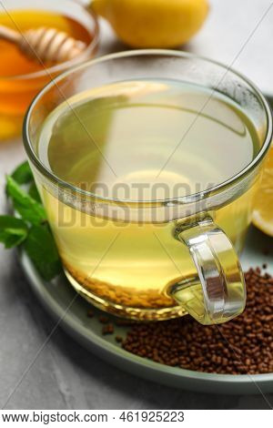 Cup Of Aromatic Buckwheat Tea, Mint And Granules On Light Grey Marble Table, Closeup