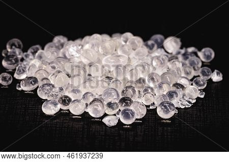 Desiccant Or Silica Gel In White Paper Packaging And Spread On Isolated Black Background, Anti Milde