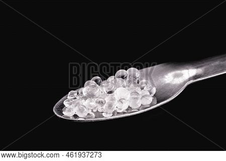 Desiccant Or Silica Gel In White Paper Packaging And Spread On Isolated Black Background, Anti Milde