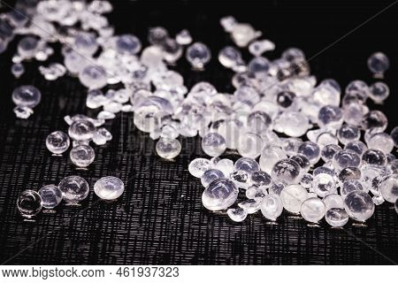 Desiccant Or Silica Gel In White Paper Packaging And Spread On Isolated Black Background, Anti Milde