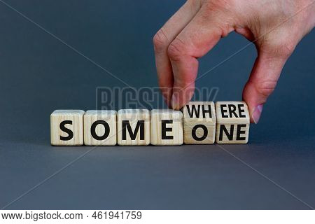 Someone Somewhere Symbol. Businessman Turns Wooden Cubes And Changes The Concept Word Someone To Som