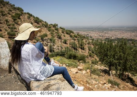 Young Woman Sitting On The Edge Of The Cliff Enjoying Beni Melal-jenifra Which Is Located Between Th