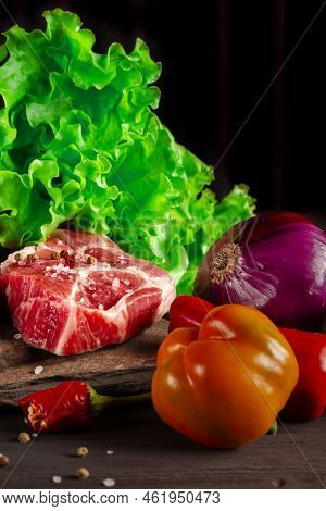 Raw Juicy Pork Steaks And Fresh Vegetables Before Cooking