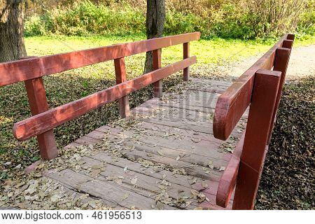Small Wooden Brodge With Red Railings In A Park In Sunny Day