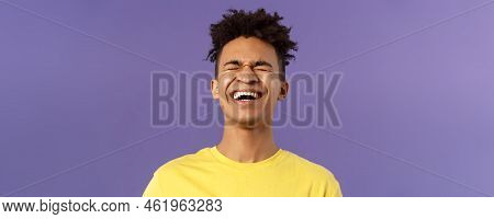 Close-up Portrait Of Happy Carefree Young Guy Laughing Loud, Chuckling Over Hilarious Joke, Bending 