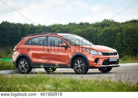 Berlin - July 2022: Kia Rio X 2021-2022 X-line Burnt Orange Parked In Parking With Forest And Grass 