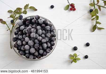 Frozen Blueberries In A Glass Bowl, Highlighted On A White Background With A Space To Copy.
