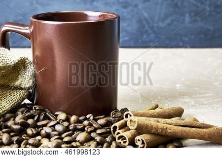 Coffee Beans Spilled Out Of A Canvas Bag Of Cinnamon And A Coffee Mug Onto A Table With A Place Of C