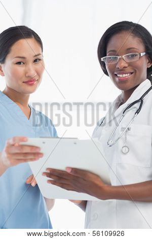 Portrait of a female doctor and surgeon with report in the bright hospital