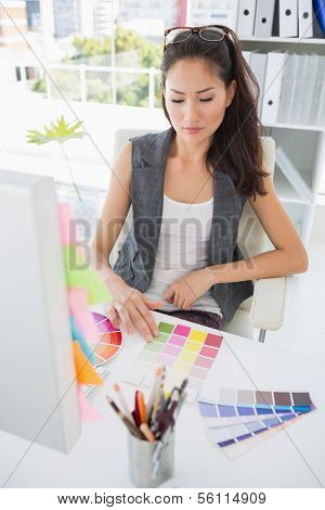 Concentrated female photo editor at work in a bright office