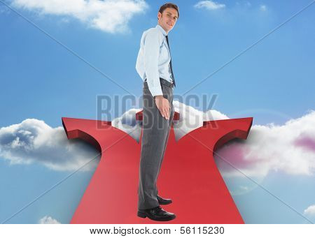 Happy businessman standing with hands in pockets against steps made of books against sky