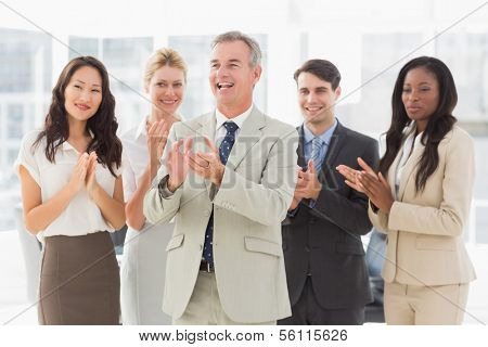 Business team standing and clapping in the office