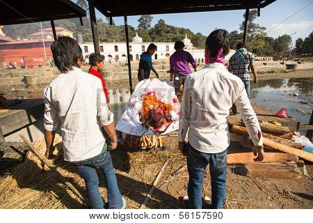 KATHMANDU, NEPAL - DEC 3: Unidentified local people during the cremation ceremony along the holy Bagmati River in Bhasmeshvar Ghat at Pashupatinath temple, Dec 3, 2013 in Kathmandu, Nepal.