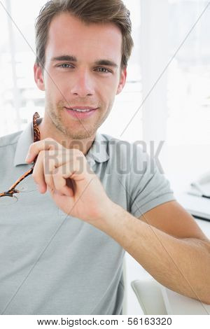Portrait of a casual male photo editor smiling in a bright office