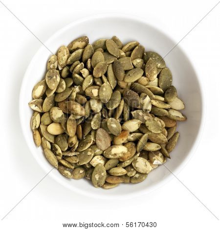 Pepitas in small white bowl, isolated.