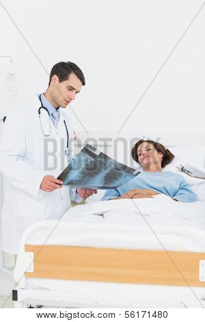 Doctor showing x-ray to female patient in the hospital