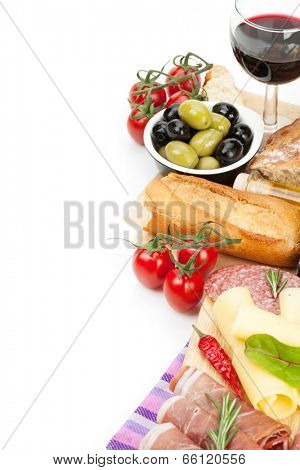 Red wine with cheese, prosciutto, bread, vegetables and spices. Isolated on white background with copy space