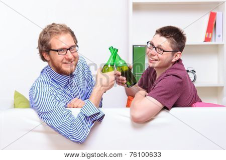 Two Young Guys With Beer On The Sofa