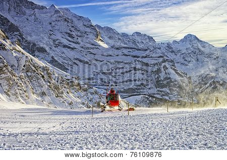 Red Helicopter Taking Off From Swiss Ski Resort Near Jungfrau Mountain