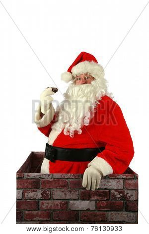 Santa Claus in a Chimney. Santa Claus exits a house through the chimney after delivering presents for all the good boys and girls with a donut that was left for him as a thank you gift. Santa Claus