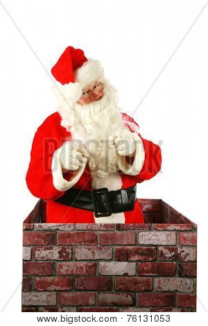 Santa Claus in a Chimney. Santa Claus smiles and points to you the viewer as he enters a chimney on Christmas eve. Santa Claus isolated on white with room for your text or graphics with clipping path