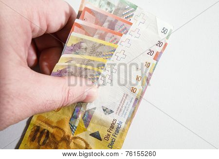 Hand Picking Up A Stack Of Swiss Franc Notes