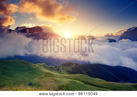 Great view of the foggy Val di Fassa valley with pass Sella. National Park. Dolomites (Dolomiti), South Tyrol. Location Canazei, Campitello, Mazzin. Italy, Europe. Dramatic scene. Beauty world.