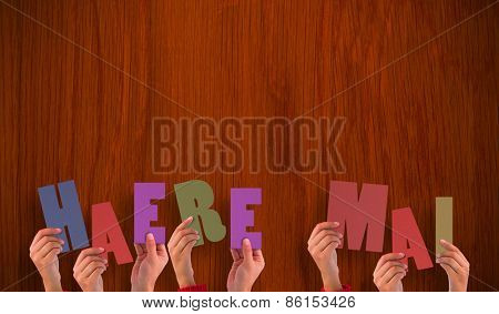 Hands holding up haere mai against wooden oak table