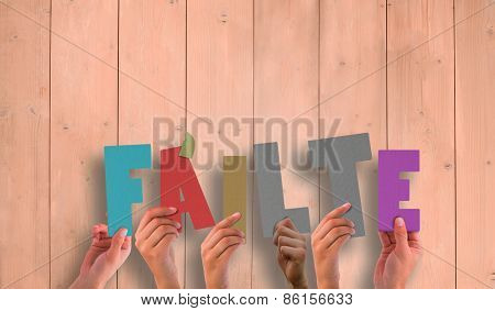 Hands holding up failte against wooden planks