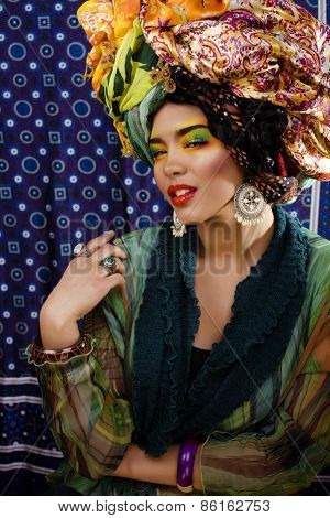 beauty bright woman with creative make up, many shawls on head