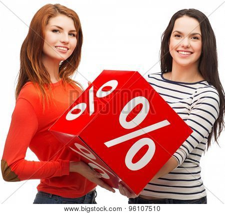 shopping, sale, and gift sconcept - two smiling teenage girls with percent sign on red box