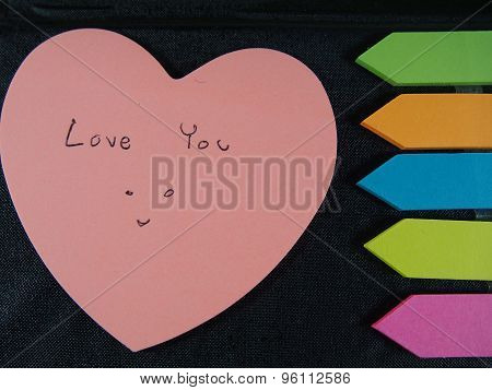 Love You With Smiling Face, Drawing And Writing On Pose Its Paper With Colorful Heart And Arrow On B
