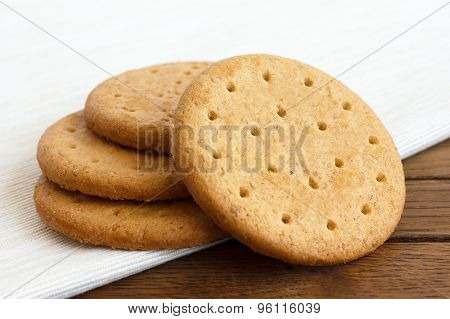 Stack Of Sweetmeal Digestive Biscuits On Dark Wood And Napkin.