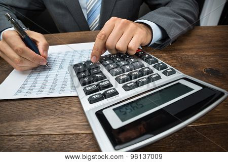 Businessperson Doing Calculation In Office