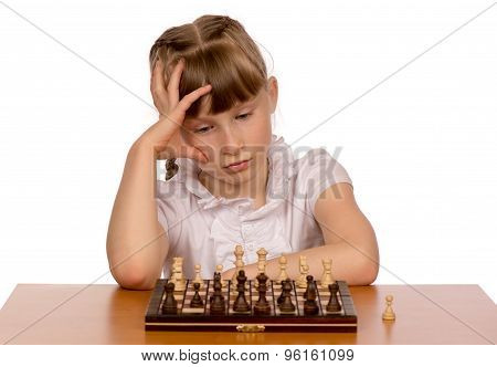 A young girl is playing chess.