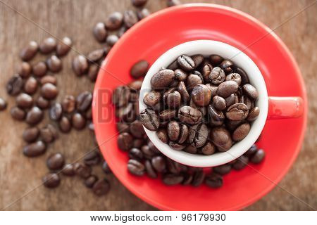 Red Coffee Cup With Coffee Beans On Wooden Table