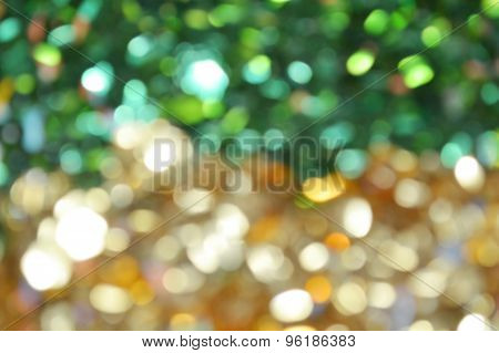 Bright and abstract blurred green and golden background with shimmering glitter