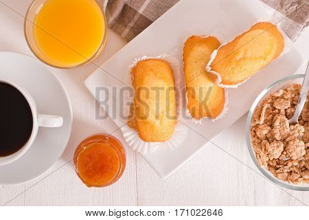 Breakfast with plumcake with jam on wooden table.