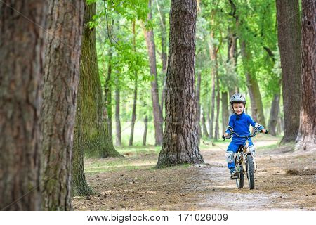 Happy Kid Boy Of 4 Years Having Fun In Autumn Or Summer Forest With A Bicycle On Beautiful Fall Spri