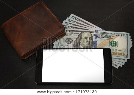 Still life after receipt of the fee - some US dollar notes, leather wallet and a cell phone on the black wooden table