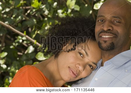 Loving African American couple hugging outside at the park.