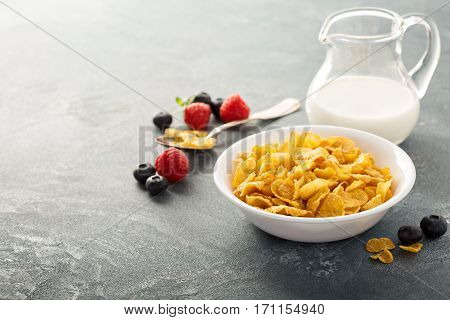 Cornflake cereals in a bowl with milk on blue background, quick breakfast