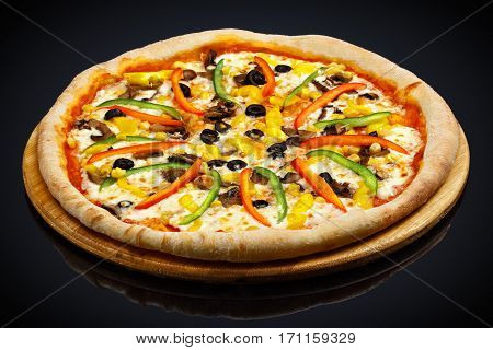 Vegetarian pizza with vegetables on a black background